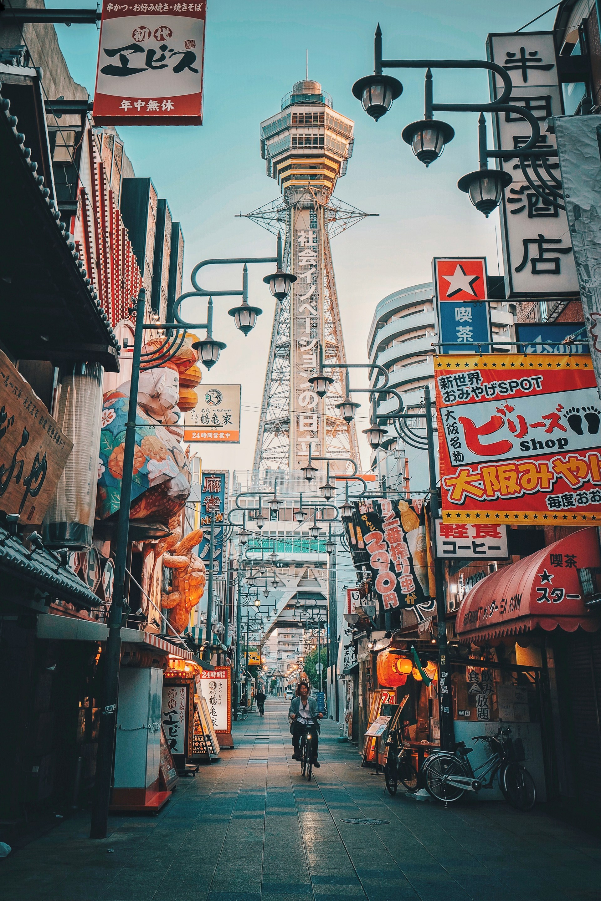 A street in Osaka Japan featuring a woman riding a bike